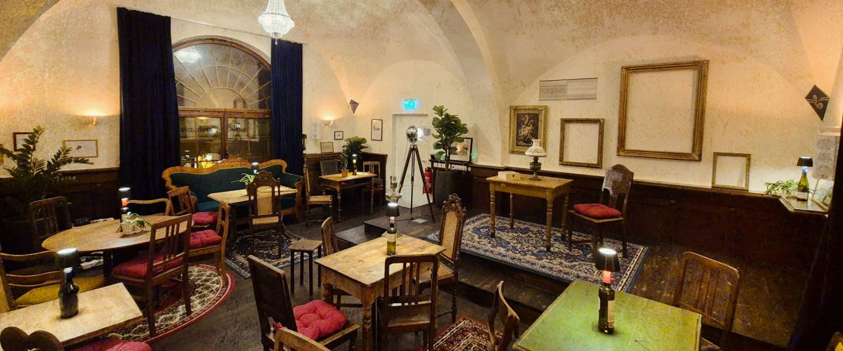 Blick in das kulturelle Wohnzimmer mit Gewölbedecke und rustikaler Bestühlung